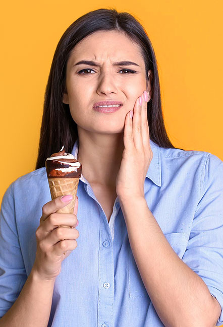 Female in her 30s in pain while eating ice cream due to dental sensitivity