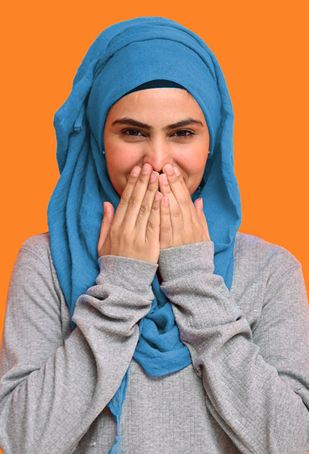 Smiling female in her 20s with covered mouth due to teeth imperfections